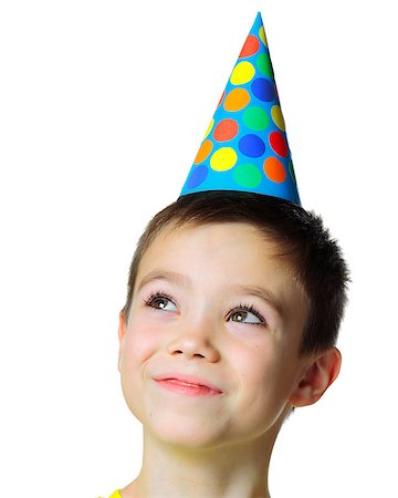 paleka (artist) - Portrait of eight years boy with birthday cap looking up on white background Stock Photo - Budget Royalty-Free & Subscription, Code: 400-08532224