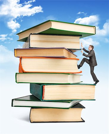 Pile of books with businessman climbing it on blue sky background Stock Photo - Budget Royalty-Free & Subscription, Code: 400-08674028