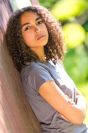 sad african children - Beautiful mixed race African American girl teenager female young woman outside, arms folded in spring or summer looking sad depressed or thoughtful Stock Photo - Budget Royalty-Free & Subscription, Code: 400-08694959