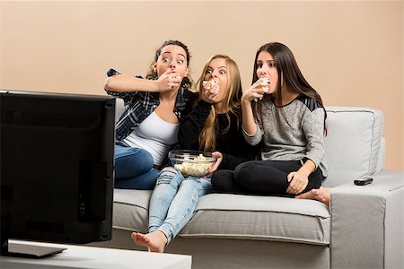 Teenage girls watching horror movie with popcorn Foto de stock - Super Valor sin royalties y Suscripción, Código: 400-08693509