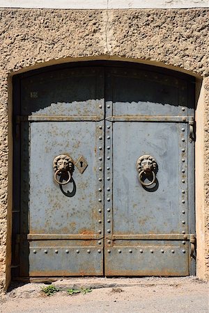 simsearch:400-04990381,k - An old heavy iron door with lion motif handles. Some rust can be seen. Stock Photo - Budget Royalty-Free & Subscription, Code: 400-08693932