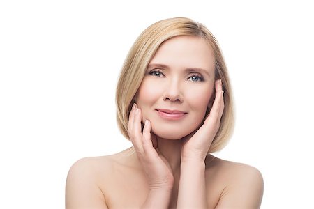 Beautiful middle aged woman with smooth skin and short blond hair touching her face. Beauty shot. Isolated over white background. Copy space. Photographie de stock - Aubaine LD & Abonnement, Code: 400-08731483