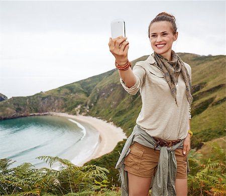 Into the wild in Spain. smiling healthy woman hiker taking selfie with smartphone in front of ocean view landscape Stock Photo - Budget Royalty-Free & Subscription, Code: 400-08731572