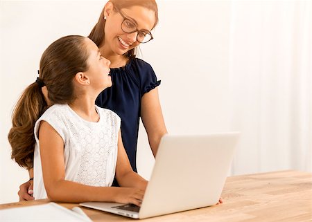 Mother helping her little daughter how to use a computer Stock Photo - Budget Royalty-Free & Subscription, Code: 400-08733024