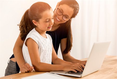 Mother helping her little daughter how to use a computer Stock Photo - Budget Royalty-Free & Subscription, Code: 400-08733026