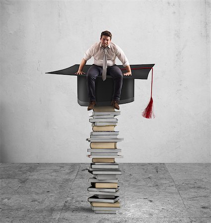 Businessman sitting on a pile of books with graduation hat Stock Photo - Budget Royalty-Free & Subscription, Code: 400-08750887