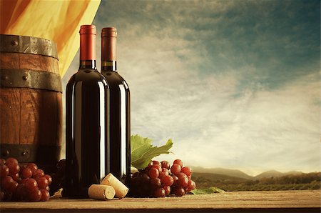 simsearch:846-05647552,k - Red wine bottles with barrel and grapes, vineyard on background Stock Photo - Budget Royalty-Free & Subscription, Code: 400-08753445