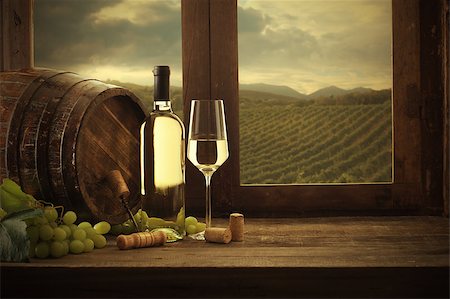 simsearch:846-05647552,k - Wine bottle and wineglass on wooden table, vineyard on background Stock Photo - Budget Royalty-Free & Subscription, Code: 400-08753454