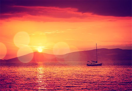 simsearch:400-07748817,k - Beautiful Seascape with Sailing Yacht in Calm Bay at Sunset. Quiet Sea. Beautiful Bokeh. Toned and Filtered Photo with Copy Space. Stock Photo - Budget Royalty-Free & Subscription, Code: 400-08775800