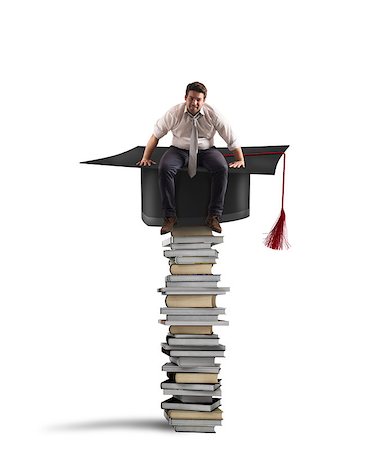 Businessman sitting on a pile of books with graduation hat Stock Photo - Budget Royalty-Free & Subscription, Code: 400-08770649