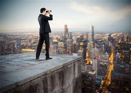Businessman looks at the city from the roof with binoculars Stock Photo - Budget Royalty-Free & Subscription, Code: 400-08786425