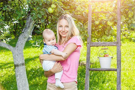 family apple orchard - Mother with her baby picking apples from an apple tree Photographie de stock - Aubaine LD & Abonnement, Code: 400-08790260