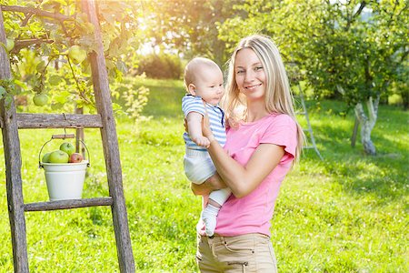 family apple orchard - Mother with her baby picking apples from an apple tree Stock Photo - Budget Royalty-Free & Subscription, Code: 400-08790261