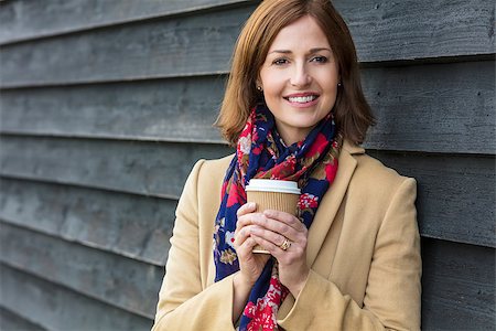 Portrait shot of an attractive, successful and happy middle aged woman female outside drinking coffee in a disposable takeaway cup. Stock Photo - Budget Royalty-Free & Subscription, Code: 400-08790653