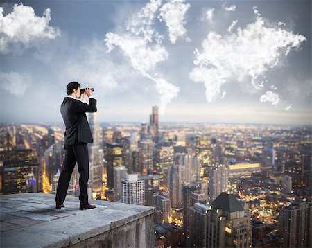 Businessman looks at the city from the roof with binoculars Stock Photo - Budget Royalty-Free & Subscription, Code: 400-08790785
