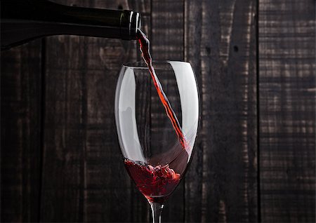 simsearch:400-04226436,k - Pouring red wine into the glass from bottle on old wooden background Stock Photo - Budget Royalty-Free & Subscription, Code: 400-08809601