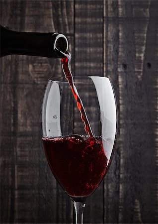 simsearch:400-04226436,k - Pouring red wine into the glass from bottle on old wooden background Stock Photo - Budget Royalty-Free & Subscription, Code: 400-08809602