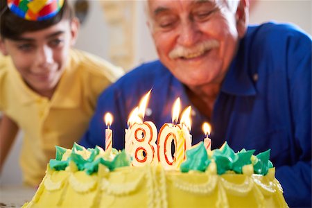 simsearch:400-06142278,k - Grandson and family celebrating senior man eighty birthday. Grandfather blowing candles with number 80 on cake and smiling. Stock Photo - Budget Royalty-Free & Subscription, Code: 400-08812598