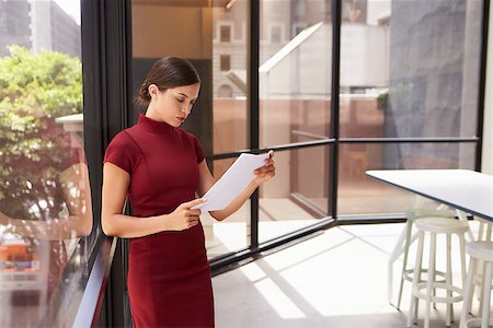 Young white businesswoman reading document in modern office Stock Photo - Budget Royalty-Free & Subscription, Code: 400-08838779