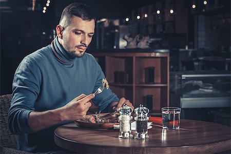 young handsome man eating at the restaurant Stock Photo - Budget Royalty-Free & Subscription, Code: 400-08831615