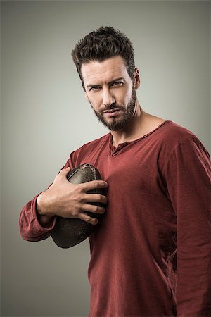 pigskin - Young attractive football player playing with ball on gray background Stock Photo - Budget Royalty-Free & Subscription, Code: 400-08832209