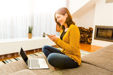 simsearch:400-04212823,k - Gorgeous young woman at home working with a laptop and texting Stock Photo - Budget Royalty-Free & Subscription, Code: 400-08890630