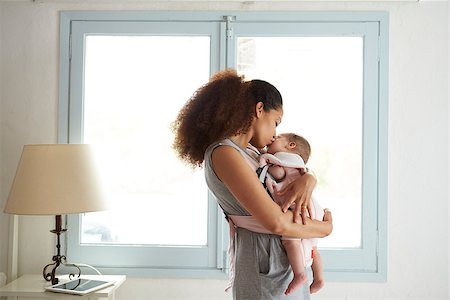 Mother Cuddling Baby Daughter At Home In Front Of Window Stock Photo - Budget Royalty-Free & Subscription, Code: 400-08891807