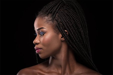 simsearch:400-04417853,k - Dark skinned model with turning head to the left side on black backstage. Close up portrait of woman with naked shoulders. Portrait of dark skinned female with bright make up and stylish hair. Foto de stock - Super Valor sin royalties y Suscripción, Código: 400-08997848