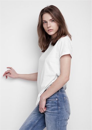 simsearch:400-04130120,k - Model test portrait with young beautiful fashion model posing on grey background. Wearing white t-shirt and jeans. Stock Photo - Budget Royalty-Free & Subscription, Code: 400-09019324