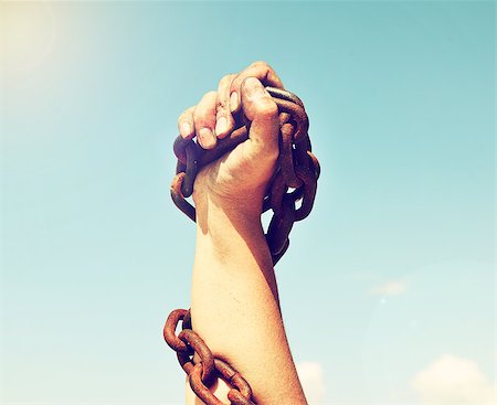 equality background hands - The female hand is lifted up and bound by an iron chain against the sky and the sun Stock Photo - Budget Royalty-Free & Subscription, Code: 400-09011052