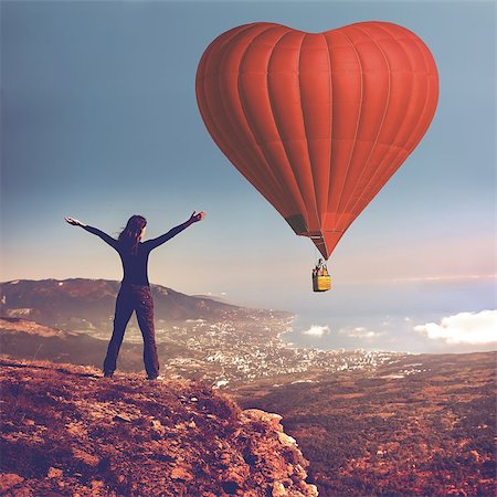 simsearch:400-06642893,k - Girl with rised hands on the top of mountain looking at big air balloon in the sky. Romantic postcard background on Valentine's Day. Sport and recreation travel theme. Nature background. Back view Foto de stock - Super Valor sin royalties y Suscripción, Código: 400-09028403