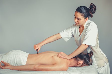 simsearch:400-05352124,k - Massage gua, sha therapy. A young professional female masseur makes Thai massage. Patient is lying down on a bed and is covered with white towel. Treatment, rest, relaxation, health care, medicine Stock Photo - Budget Royalty-Free & Subscription, Code: 400-09028926