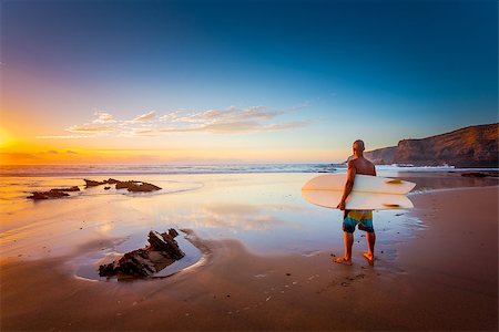 silhouettes surfboards in the sand - Young man on the beach with his surfboard looking at waves Stock Photo - Budget Royalty-Free & Subscription, Code: 400-09084364