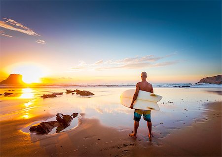 silhouettes surfboards in the sand - Young man on the beach with his surfboard looking at waves Stock Photo - Budget Royalty-Free & Subscription, Code: 400-09084365