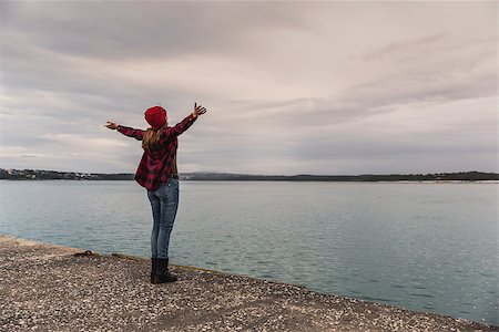 Beautiful woman standing on a pier with arms raised feeling the freedom Stock Photo - Budget Royalty-Free & Subscription, Code: 400-09084911