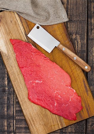 Fresh raw beef steak in black on kitchen wooden board with hatchet knifeisolated on white background Stock Photo - Budget Royalty-Free & Subscription, Code: 400-09082835