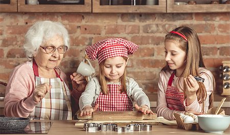 Grandma and granddaughters are spreading dough using a rolling pin Foto de stock - Super Valor sin royalties y Suscripción, Código: 400-09113364