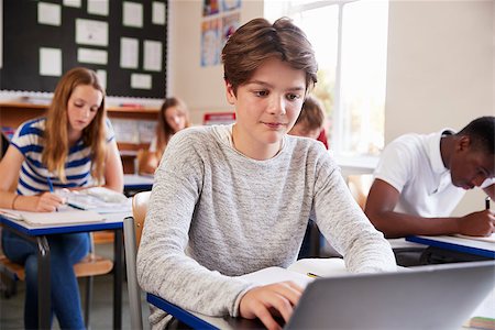 Male Pupil Sitting At Desk In Class Room Using Laptop Stock Photo - Budget Royalty-Free & Subscription, Code: 400-09122031