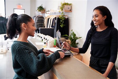 simsearch:614-07806416,k - Woman making card payment at the counter in a clothing store Photographie de stock - Aubaine LD & Abonnement, Code: 400-09122939