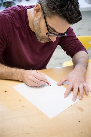 simsearch:400-07899762,k - Young Designer Drawing the Sketch Using Pencil on the Wooden Table in the Bright Studio Stock Photo - Budget Royalty-Free & Subscription, Code: 400-09132520