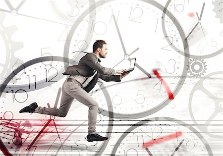 past due - Business man runs fast with a laptop on a background of clocks Stock Photo - Budget Royalty-Free & Subscription, Code: 400-09132789