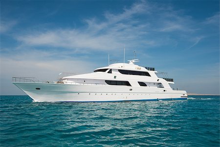 A luxury private motor yacht under way on tropical sea with bow wave Stock Photo - Budget Royalty-Free & Subscription, Code: 400-09140861