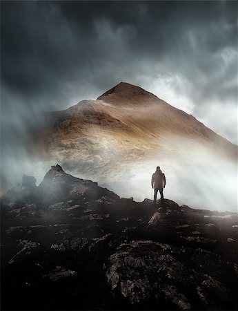 silhouette of man standing in a mountain top - A person hiking looks onwards at a mountain shrouded in mist and clouds with the peak visible. Scenic landscape photo composite. Stock Photo - Budget Royalty-Free & Subscription, Code: 400-09154872