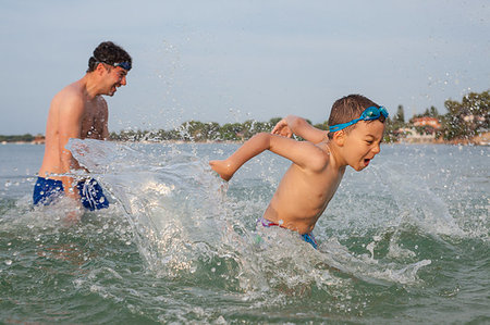 father son bath - A boy around six is playing in the sea water with his father splashing. Foto de stock - Super Valor sin royalties y Suscripción, Código: 400-09222532