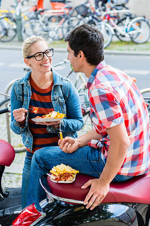 Tourist couple taking rest during scooter tour through berlin and eating currywurst and chips Stock Photo - Budget Royalty-Free & Subscription, Code: 400-09223860