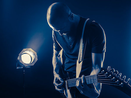 picture of the blue playing a instruments - Photo of a guitar player with a beard playing in a dark club with spotlight in background. Stock Photo - Budget Royalty-Free & Subscription, Code: 400-09273744