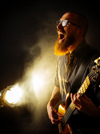 picture of the blue playing a instruments - Photo of a screaming bass player with a beard playing in a dark club with spotlight in background. Stock Photo - Budget Royalty-Free & Subscription, Code: 400-09273746