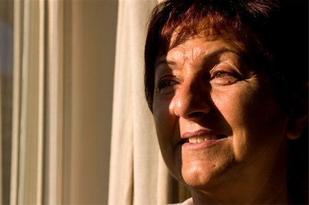 elder care - Woman looking out the window towards the sun Foto de stock - Super Valor sin royalties y Suscripción, Código: 400-03908692