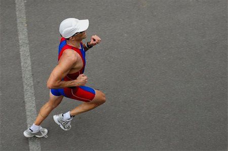 simsearch:400-03915806,k - A marathon runner crossing a line, taken from above. Motion blur on his feet. Space for text on the tarmac in front of him. Stock Photo - Budget Royalty-Free & Subscription, Code: 400-03909026