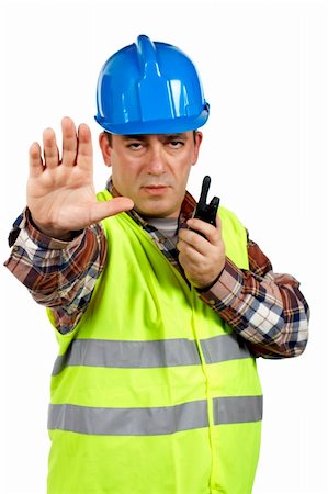 Construction worker with green safety vest worker talking with a walkie talkie and orders to stop. Hand on focus Stock Photo - Budget Royalty-Free & Subscription, Code: 400-03912293
